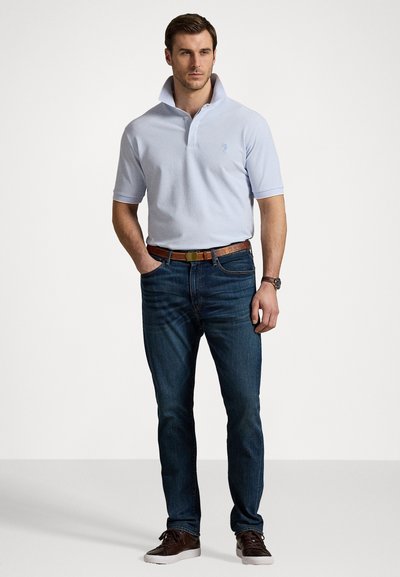 Lyseblå polo skjorte med krage, korte ermer, og subtile striper. Kombinert med mørkeblå jeans og brunt lærbelte, brukt med fritidssko.