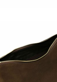 Pochette in camoscio marrone con forma curva, dotata di una cerniera dorata e una fodera interna nera; texture liscia, design minimalista.