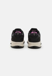 Svarta och rosa atletiska skor med en strukturerad ovandel, prickig beige mellansula och ett aggressivt mönster på sulan.