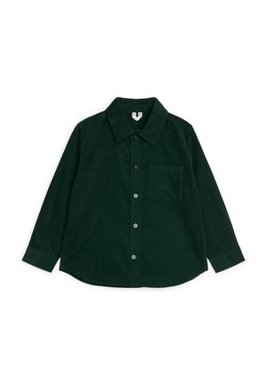 Camisa de pana de manga larga de color verde oscuro con botones delanteros, un bolsillo en el pecho y un cuello clásico, colocada plana sobre un fondo blanco.