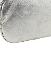 Silberne Metallic-Clutch mit glatter Oberfläche und abgerundeten Ecken, die ein minimalistisches Design und einen einzelnen Griff aufweist.