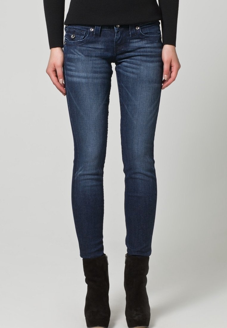 Mörkblå skinny jeans med en lätt blekning. Denimtyget har subtila slitningar vid låren. Femficksdesign med metallaccenter.