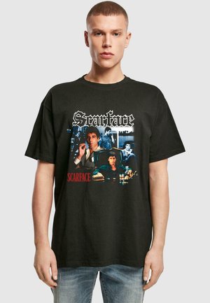 Black cotton t-shirt featuring a graphic print from "Scarface" with images in color and white text. Loose fit with short sleeves.
