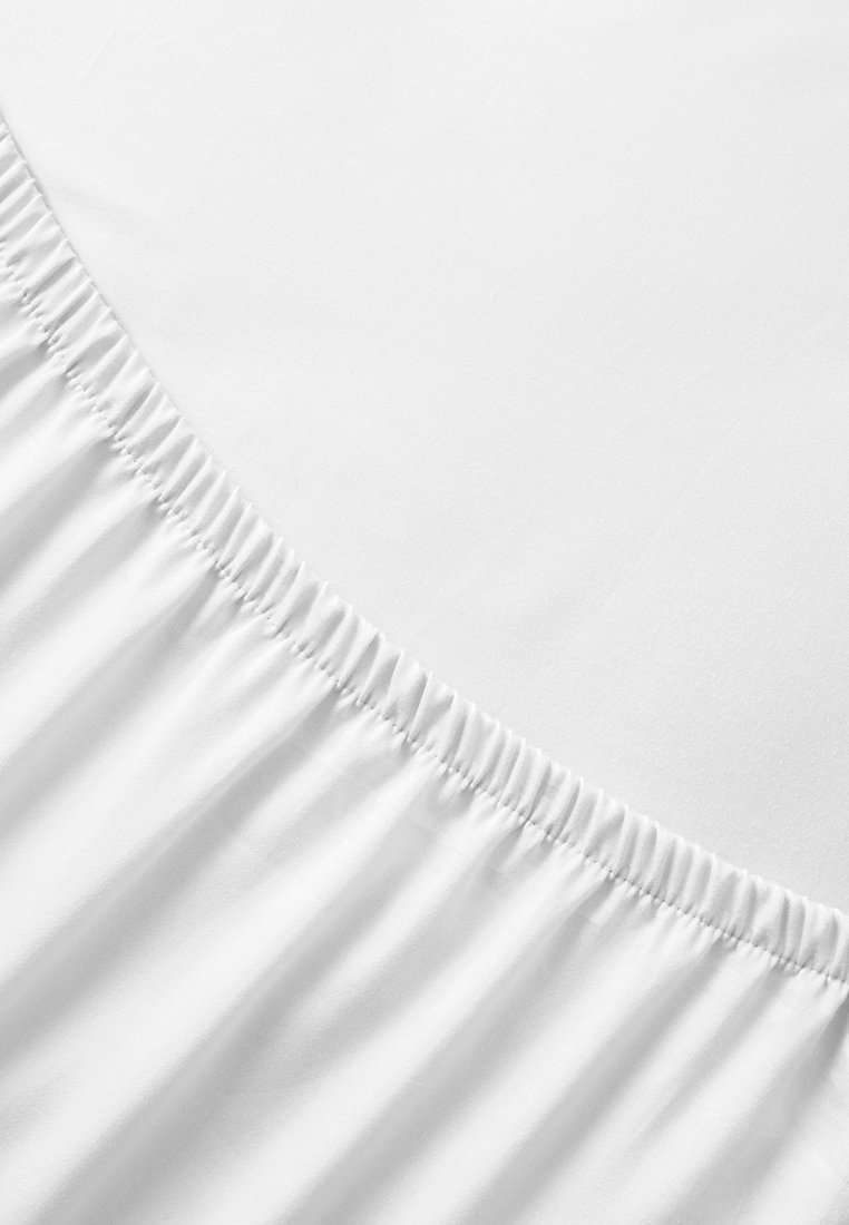 Weißes Spannbettlaken mit elastischem Saum, glatter Textur und einheitlicher Farbe. Zeigt einen leichten Glanz in einem natürlichen Lichtsetting.