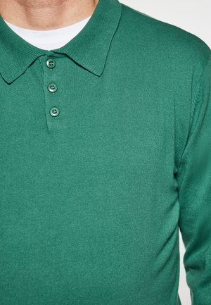 Groene polo shirt van gestructureerde stof met een klassieke kraag, een drie-knopen bediening en ribbeldetails.