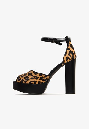 Tacchi a piattaforma con stampa leopardata e cinturino alla caviglia in vernice nera. Presentano un'apertura per le dita e un tacco spesso, combinando materiali in finta suede e finiture lucide.