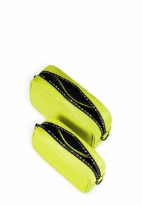 Zwei leuchtend gelbe Kosmetiktaschen aus glänzendem Material, mit schwarzen Reißverschlüssen und weißer Markenkennzeichnung. Eine Tasche ist kleiner als die andere.