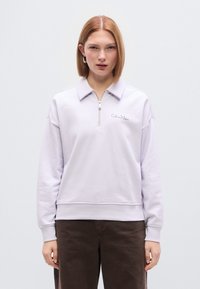 Ανοιχτό μωβ φούτερ με φερμουάρ και γιακά, με μπροστινή τσέπη και κεντημένο το λογότυπο «Calvin Klein». Μαλακό υλικό με άνετη εφαρμογή.