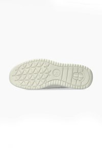 Semelle de chaussure en caoutchouc blanc avec un motif texturé présentant des grips hexagonaux et un logo circulaire sur le talon. Design lisse et plat.