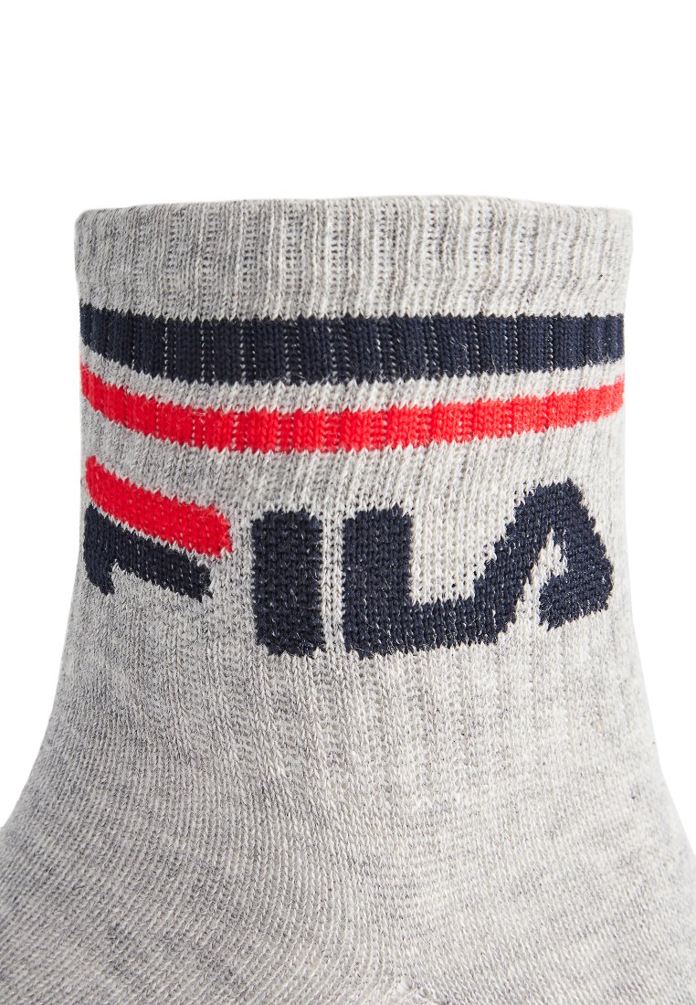 Szare bawełniane skarpety z czerwonymi i granatowymi poziomymi paskami na górze oraz logo marki "FILA" w ciemnoniebieskim kolorze na kostce.