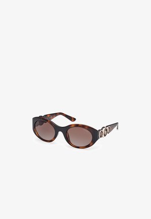Tortoiseshell sunglasses with oval lenses, brown gradient tint, wide frames, and decorative gold-tone accents on the temple.