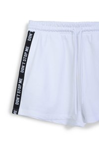 Pantaloni corti sportivi bianchi con elastico in vita, caratterizzati da strisce laterali nere con la scritta "NON FERMARE ME" in grassetto. Texture liscia, design casual.