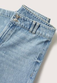 Jeans de mezclilla azul claro con una cintura alta, que presentan dos botones plateados y costuras en contraste a lo largo de los lados y la cintura.