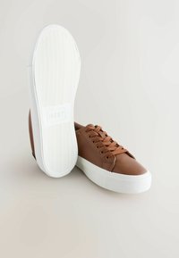 Ruske nahkakengät pyöreällä varpaalla, littealla valkoisella kumipohjalla ja nauhalla suljettavalla suunnittelulla, jossa on teksturoidut pinnat ja huomaamattomat ompeluyksityiskohdat.