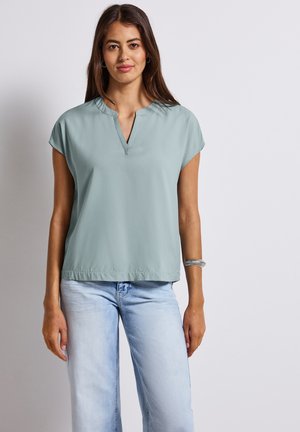 Maglietta a maniche corte di colore azzurro chiaro con scollatura a V. Realizzata in tessuto morbido, presenta una vestibilità rilassata e un orlo che si ferma in vita.
