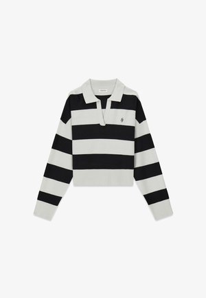 Melnā un baltā svītrainā īsā džempera ar pola apkakli un ribota auduma aprocēm. Krūtīs ir neliels izšūts logo.