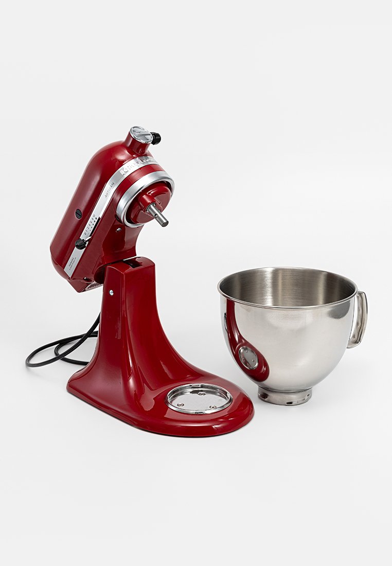 Roter Standmixer mit Geschwindigkeitsregelung und Motoraufsatz, neben einer separaten Rührschüssel aus Edelstahl auf weißem Hintergrund.