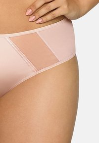 Ljust rosa trosa gjord av mjukt tyg med genomskinliga paneler på sidorna. Har en mjuk elastisk midjeband och sömlösa kanter för komfort.