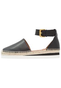 Espadrille de cuero negro con correa al tobillo, herrajes dorados, ribete de yute, punta redonda y suela de goma. Diseño clásico con un aspecto minimalista.