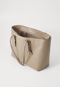 Beige leren totebag met twee lange hengsels, ritssluiting en een binnenzak. Heeft gouden hardware en een logo hanger.