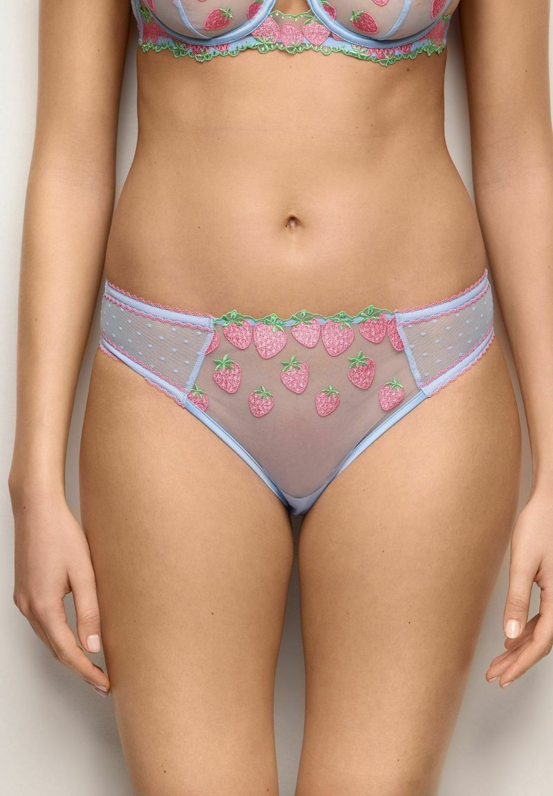 Conjunto de lencería azul celeste translúcido con fresas bordadas en rosa y detalles de hojas verdes en el sujetador y las bragas, llevado por una persona de pie.