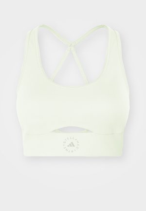 Šviesiai žalias sportinis liemenėlis su išpjovų dizainu ir kryžminėmis petnešomis. Pasirinktas lygaus paviršiaus ir ant juostos yra apvalus logotipas.