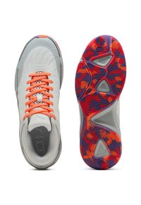 Scarpe da ginnastica grigio chiaro con lacci arancioni e tomaia in rete. La suola testurizzata presenta motivi geometrici multicolori in rosso, viola e arancione.