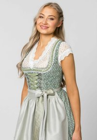 Traditional dirndl dress featuring a green brocade bodice with lace trim, a white lace blouse, and a gray satin skirt with a matching bow.