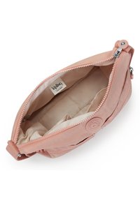 Rosa, mjuk textil clutchväska med dragkedja. Inuti har den beige foder och fack för organisering. Logotypen är synlig.