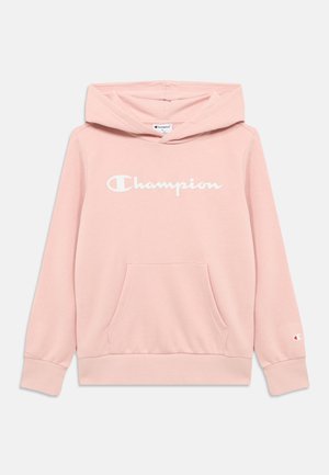 Hellrosa Kapuzenpullover mit einer vorderen Kängurutasche. Verfügt über ein großes weißes "Champion"-Logo auf der Brust und elastische Bündchen an den Ärmeln.