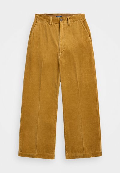 Pantaloni in corduroy giallo senape, con gambe larghe, texture a coste verticali, tasche frontali e chiusura con un bottone.