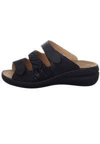 Schwarze Sandale mit drei verstellbaren Riemen; glattes und strukturiertes Material; offenes Design für die Zehen; konturierte Fußbett; niedriger Keilabsatz.