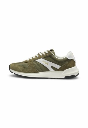 Niedriger olivgrüner Sneaker mit weißen Veloursakzenten, weißen Schnürsenkeln, schwarzer Sohle und goldfarbenem "HUGO"-Logo an der Seite.