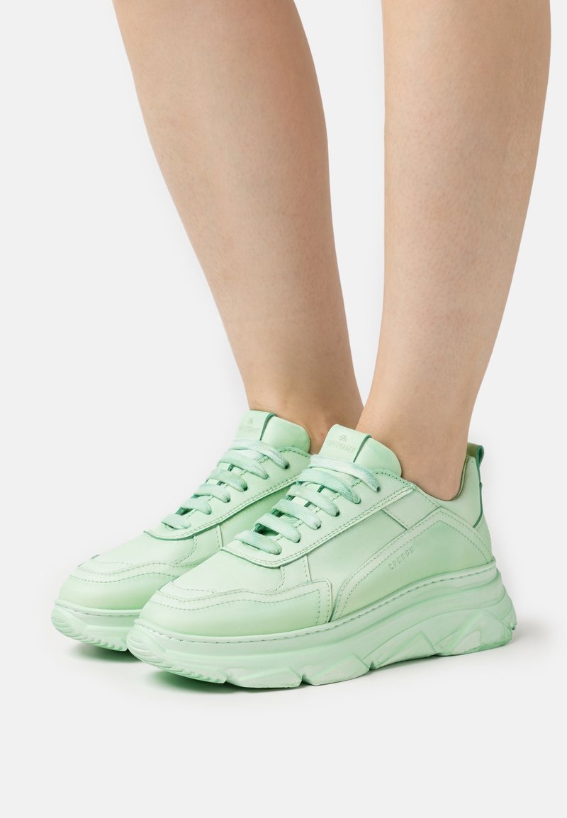 Sneaker verde chiaro con tomaia in pelle liscia, linguetta imbottita, suola spessa e design con lacci e occhielli rinforzati.