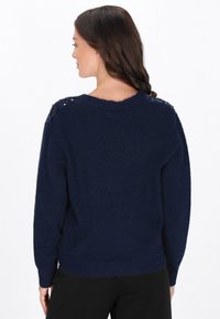 Maglione lavorato a maglia blu navy con una vestibilità comoda, caratterizzato da dettagli a punto texturizzato sulle spalle e un orlo a coste.
