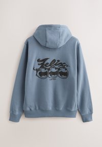 Niebieska bluza z polaru z czarnym nadrukiem postaci Feliksa Kota na plecach, z kapturem ze sznurkiem oraz ściągaczami na mankietach i dole.