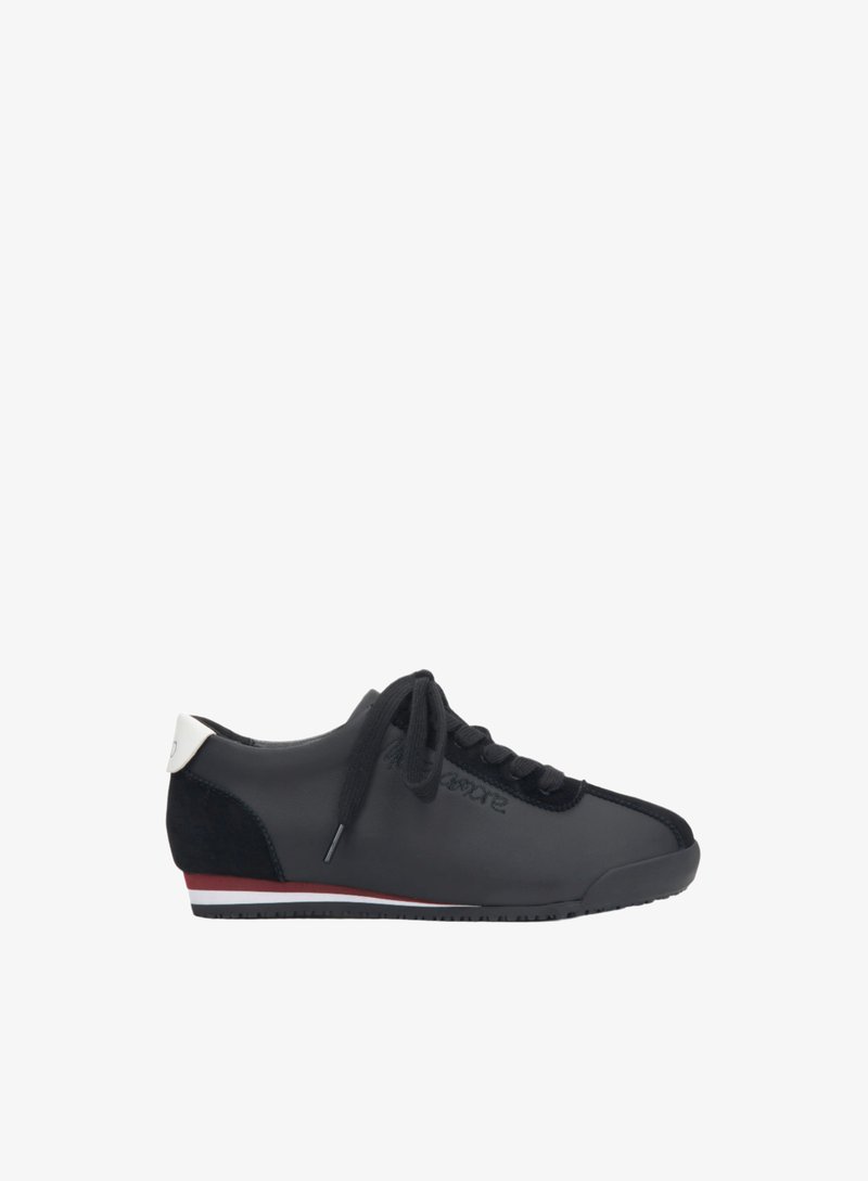 Czarne sneakersy z gładką skórzaną cholewką, zamszowymi akcentami i białą łatką na pięcie. Posiadają czarne sznurowadła i niskoprofilową gumową podeszwę z czerwoną stripe.
