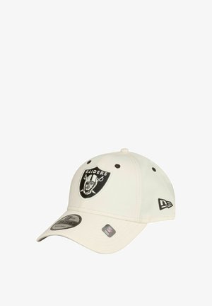 Casquette de baseball crème réglable avec un logo noir des Raiders à l'avant, des coutures grises et une visière incurvée. Étiquette de marque sur le côté.