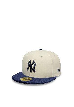 Weiße und marineblaue New York Yankees Baseballkappe mit gesticktem Logo und flachem Schirm, aus einem Winkel gezeigt.