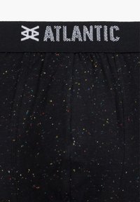 Czarne figi z dopasowanym pasem. Materiał ma wielokolorowe plamki. Pas eksponuje nazwę marki "ATLANTIC" na białym tle.