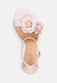 Różowa skórzana sandał z dwoma kwiatowymi akcentami na pasku, otwarty przód, pasek wokół kostki z klamrą oraz teksturowana wkładka z brandingiem.
