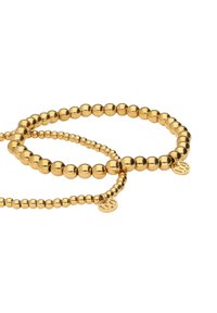 Due braccialetti di perline color oro di varie dimensioni, con perline sferiche lisce e piccoli pendenti rotondi con un logo.