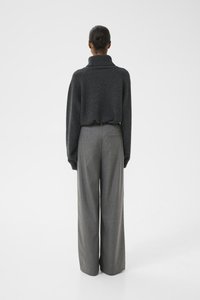 Gray oversized sweater with a high collar paired with gray wide-leg trousers, featuring a textured finish and tailored design.