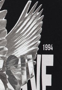 Witte vogelvleugel graphic die gedeeltelijk een grote witte tekst met het jaar "1994" op een zwarte achtergrond bedekt.