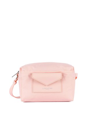 Sac bandoulière rectangulaire rose pâle avec poche avant en forme d'enveloppe, fermeture éclair argentée et sangle réglable sur fond blanc.