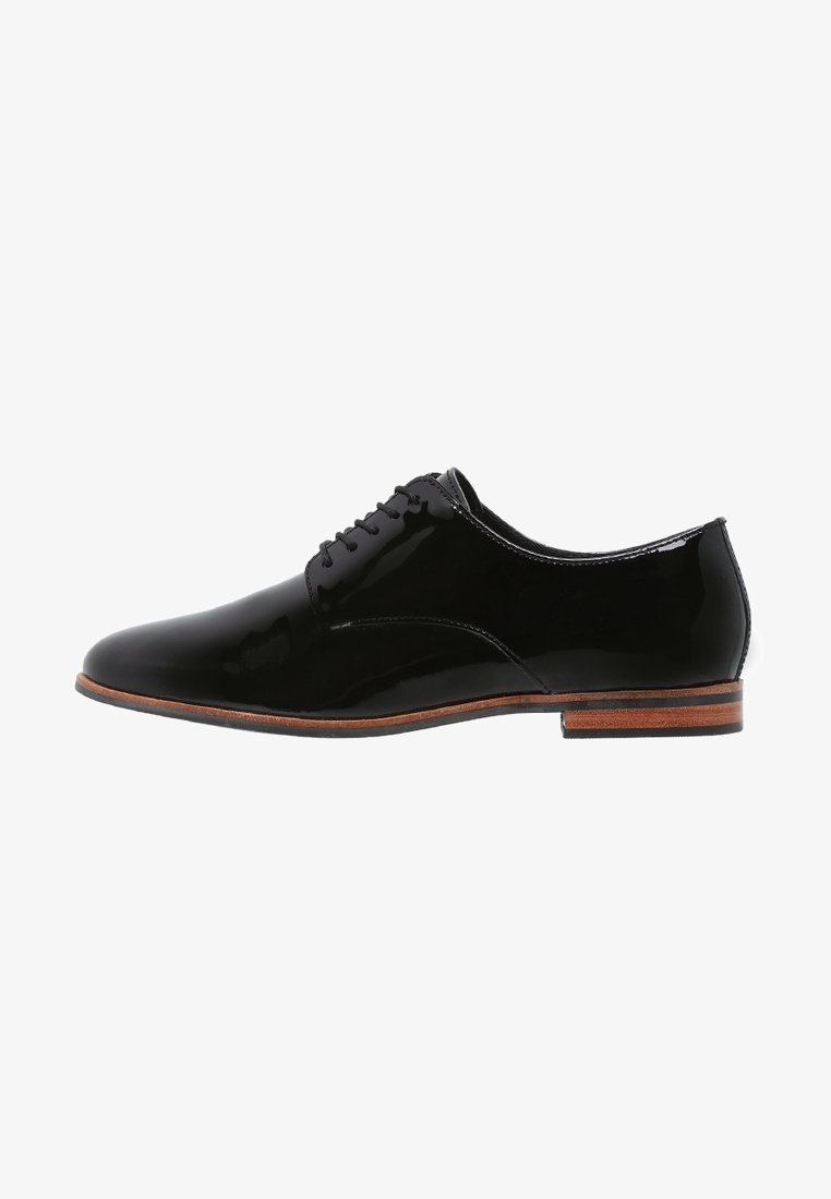 Chaussure Oxford pour homme en cuir verni noir avec laçage fermé, semelle marron et petit talon empilé, vue de côté extérieur.