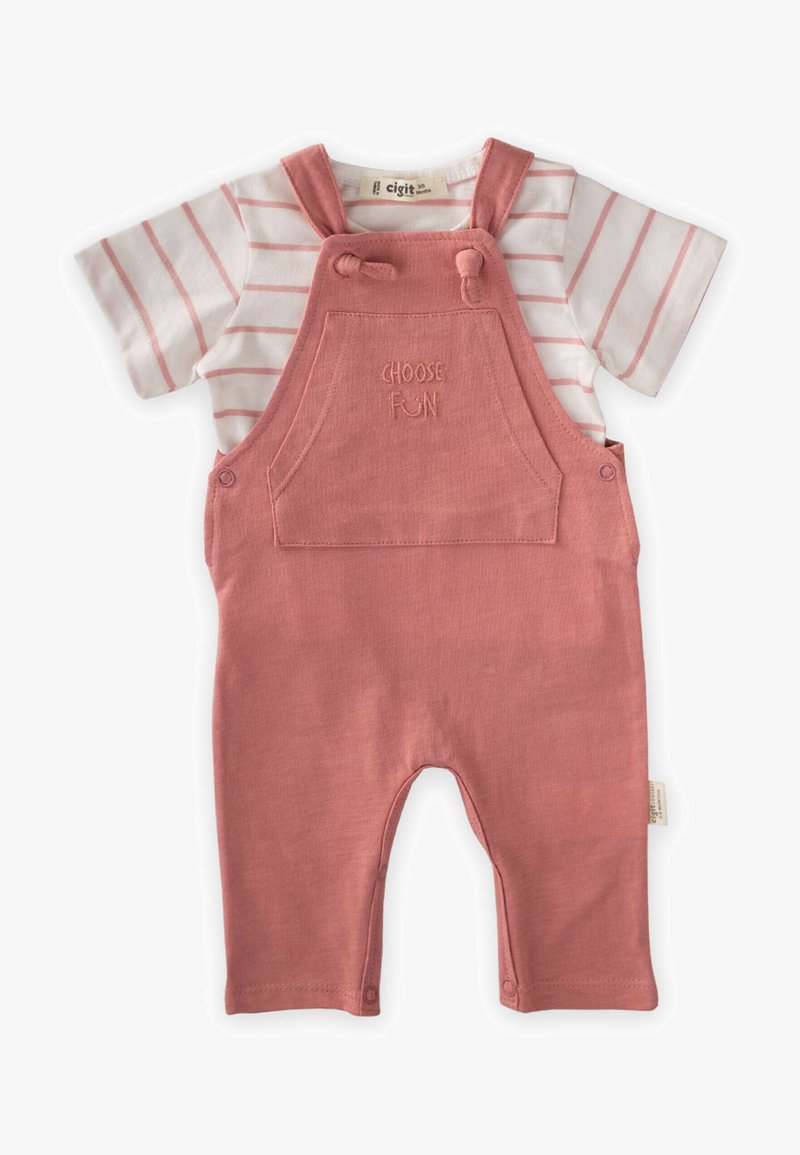 Peto rosa con una camiseta de rayas blanca y rosa debajo. El peto cuenta con un bolsillo con "ELIGE LA DIVERSIÓN" bordado y tirantes ajustables.