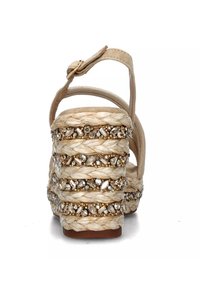 Sandalo beige con tacco alto, realizzato in pelle con rafia intrecciata e abbellito con strass trasparenti, dotato di cinturino con fibbia e tacco spesso.