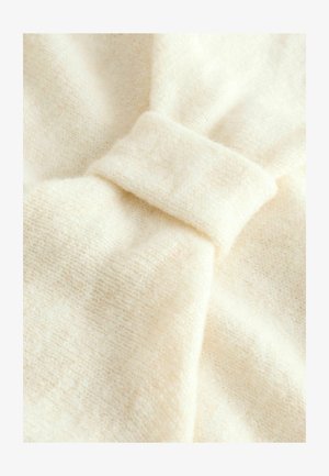Cream-colored fabric with a soft texture, featuring a prominent knot detail and subtle woven pattern.