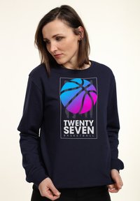 Felpa blu navy con maniche lunghe, caratterizzata da una grafica di un pallone da basket in gradiente blu e rosa, e la scritta "TWENTY SEVEN BASKETBALL".
